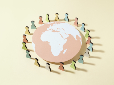 Paper style globe, centered on Africa, with silhouettes of 'people' circling it. Created by freepik